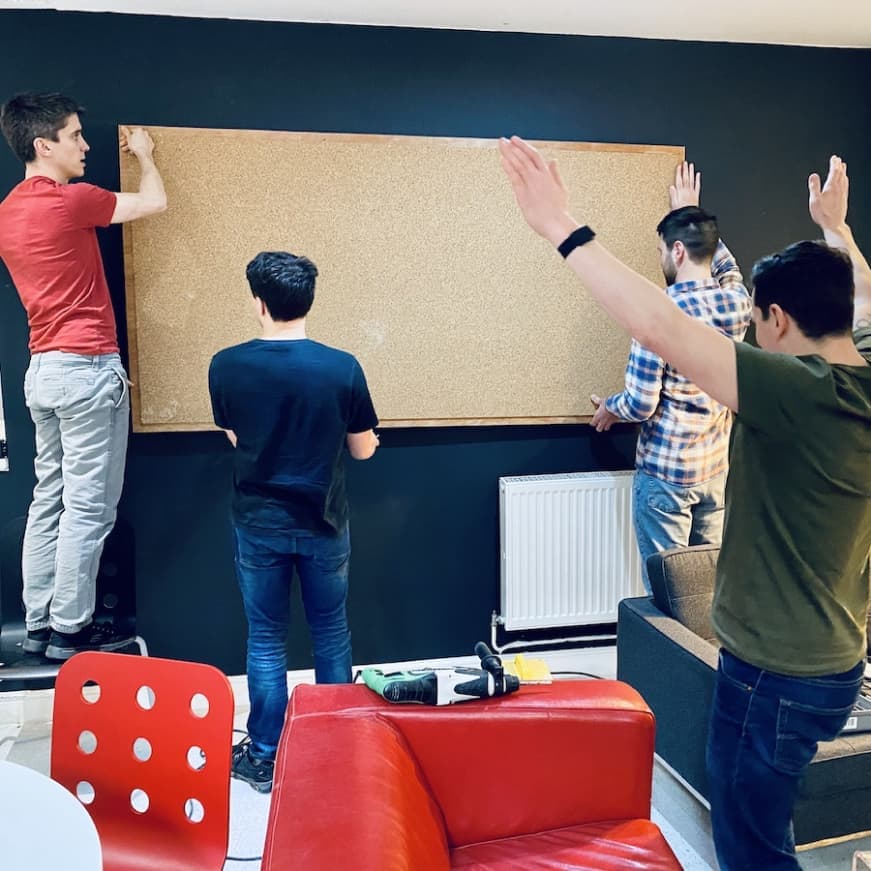Multiple Propeller Exmouth community members hanging a cork board